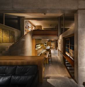 Black-leather-sofa-wooden-desk-square-wooden-dining-table-wooden-dining-chair-concrete-floor-concrete-stairway-glass-window